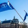 NATO flags flying in The Hague, The Netherlands. Background: The Hague by day, with blue skies.